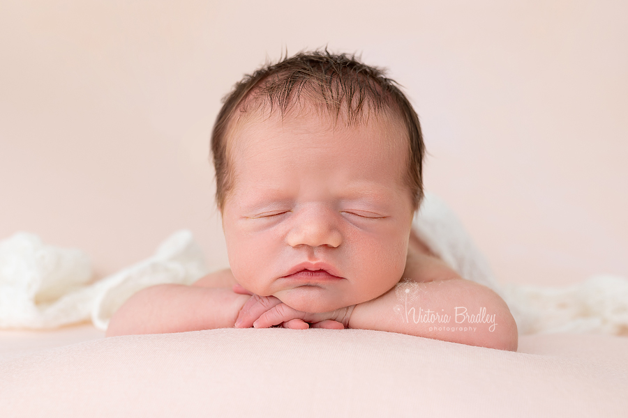 chin on hands pose newborn