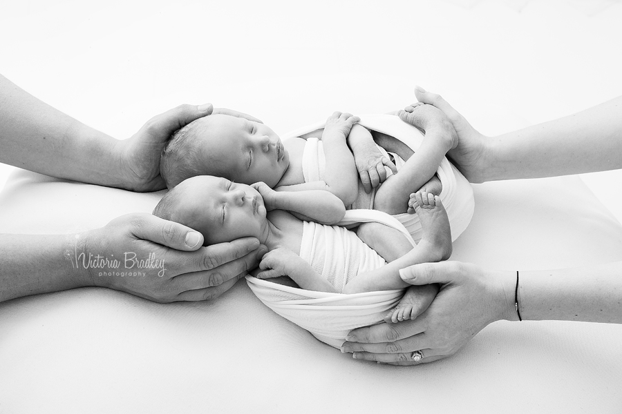 newborn twins in mummy and daddys hands