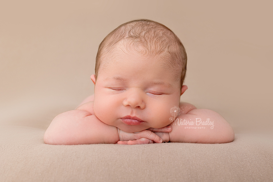 chin on hands pose baby boy newborn