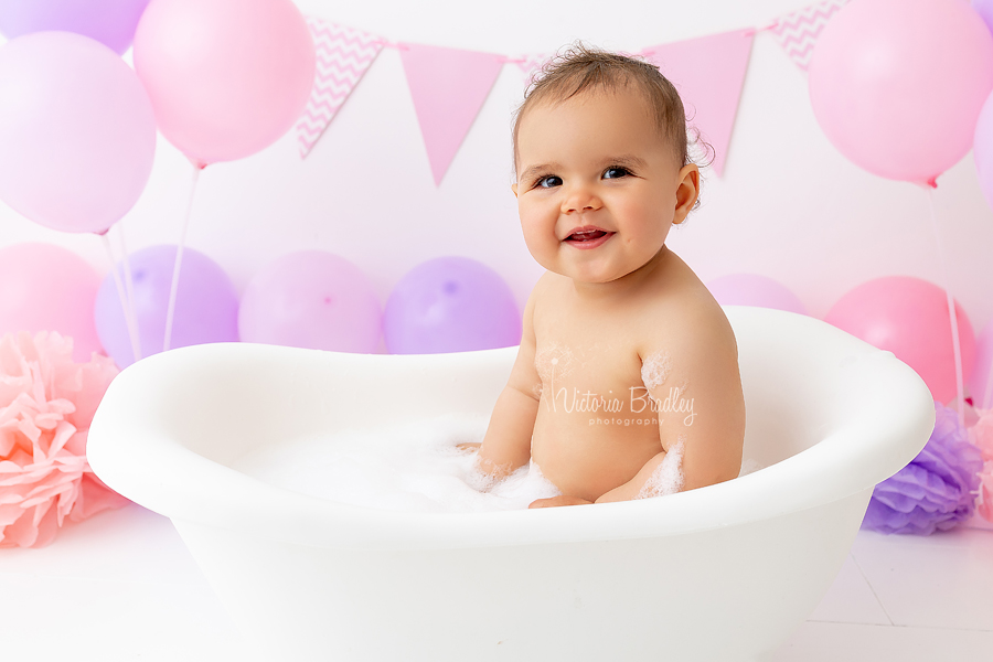 baby girl in white mini roll tip bath photograph 