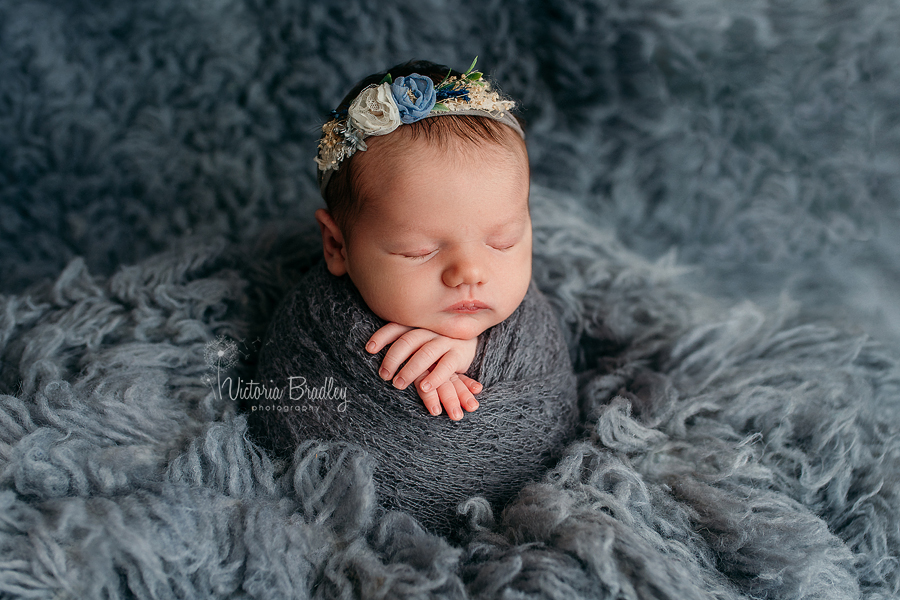 newborn baby girl wrapped in grey knitted wrap potato sack pose photography