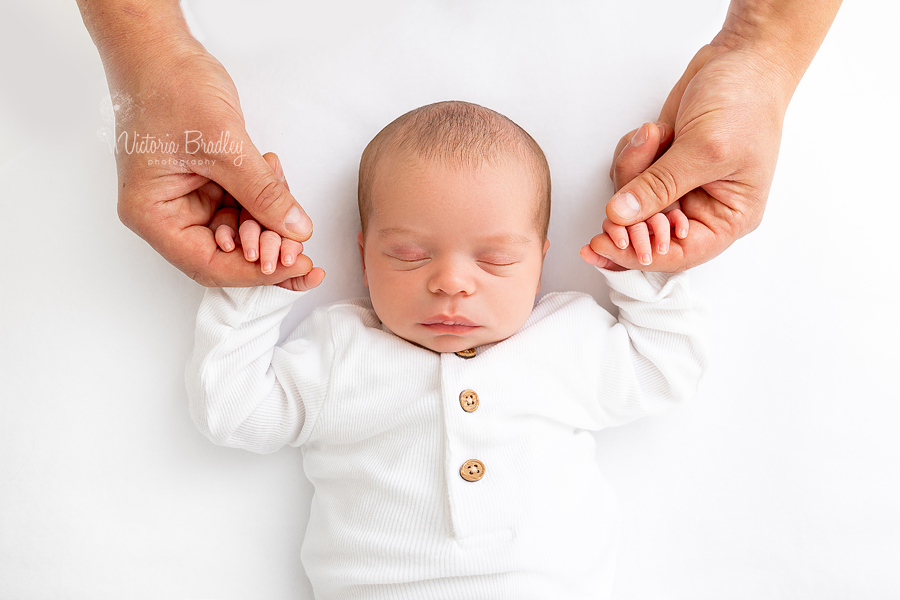 pure newborn photography baby holding Daddy's hands