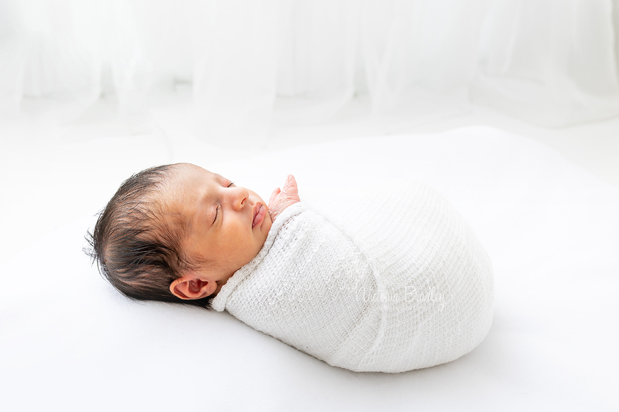 wrapped newborn on white beanbag