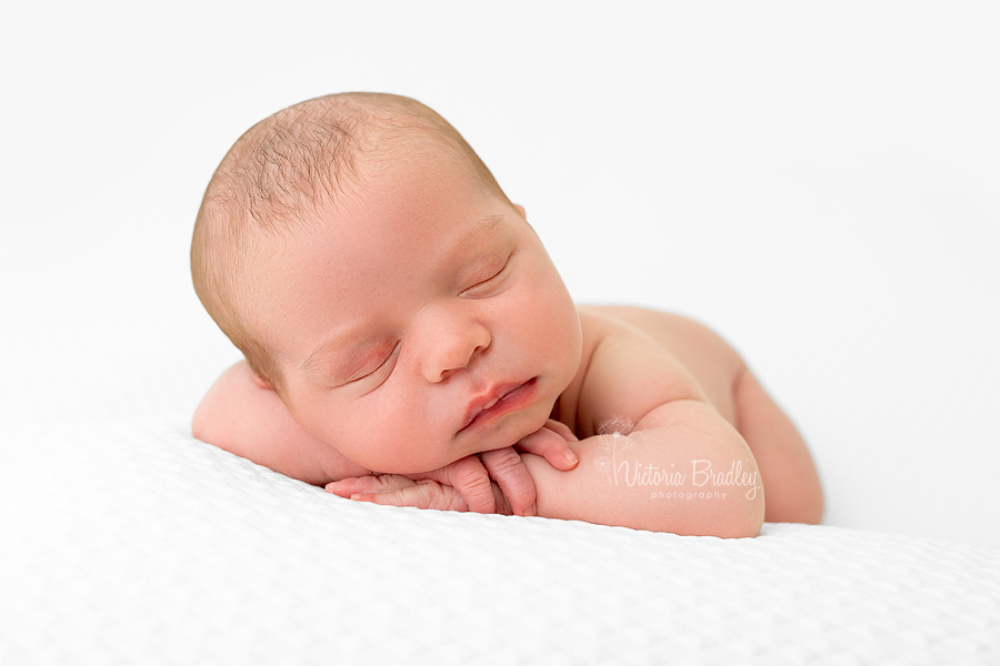 sleepy newborn chin on hands