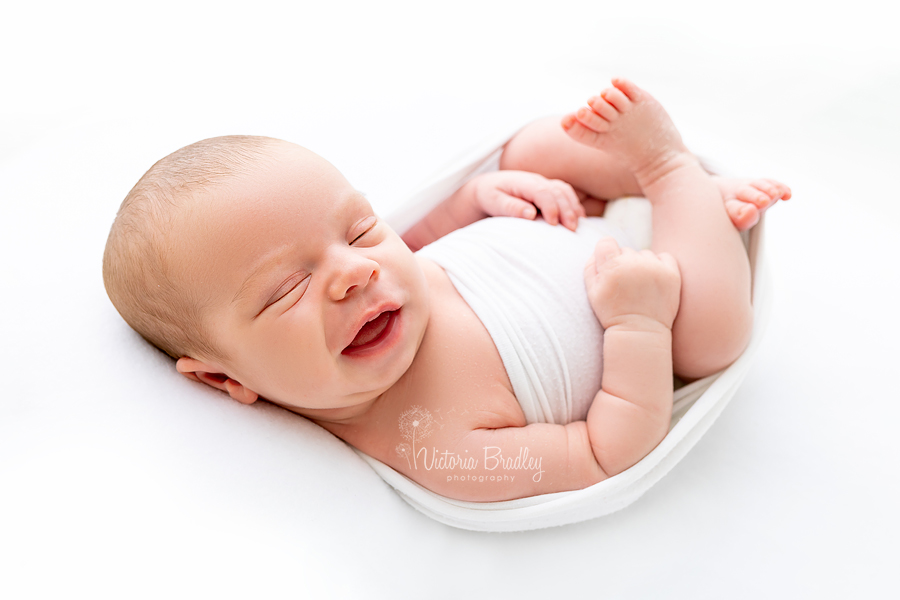 smiling sleepy newborn on white backdrop, pure newborn session