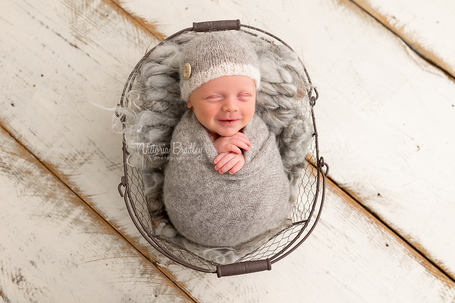 smiling wrapped newborn in grey