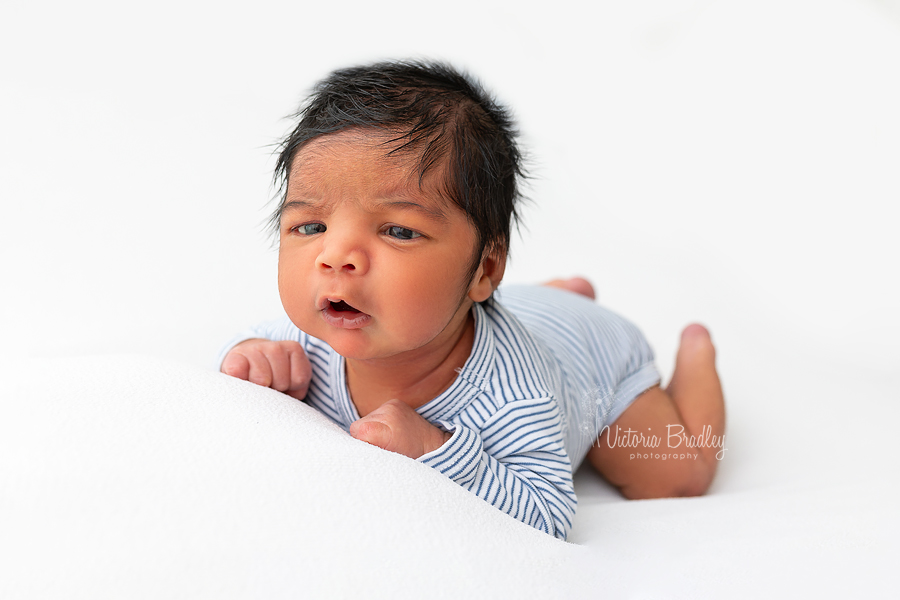 awake newborn on tummy holding up head