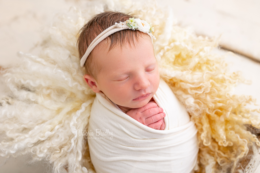 wrapped newborn on yellow curls
