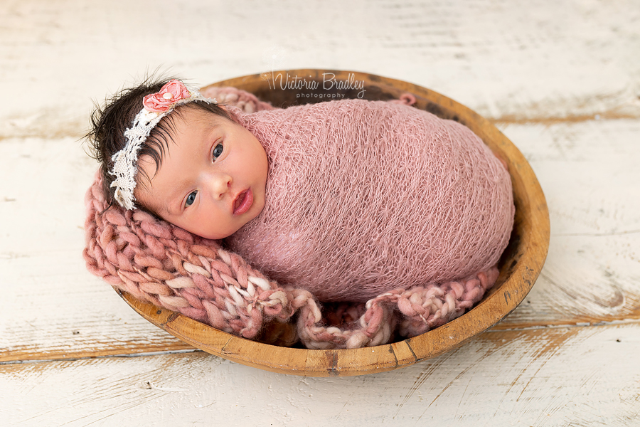 awake newborn wrapped in rose pink