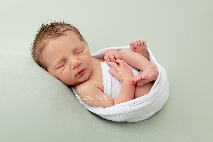 newborn baby boy on sage green