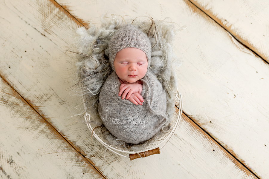 swaddled newborn photography in grey knitted wrap and bonnet