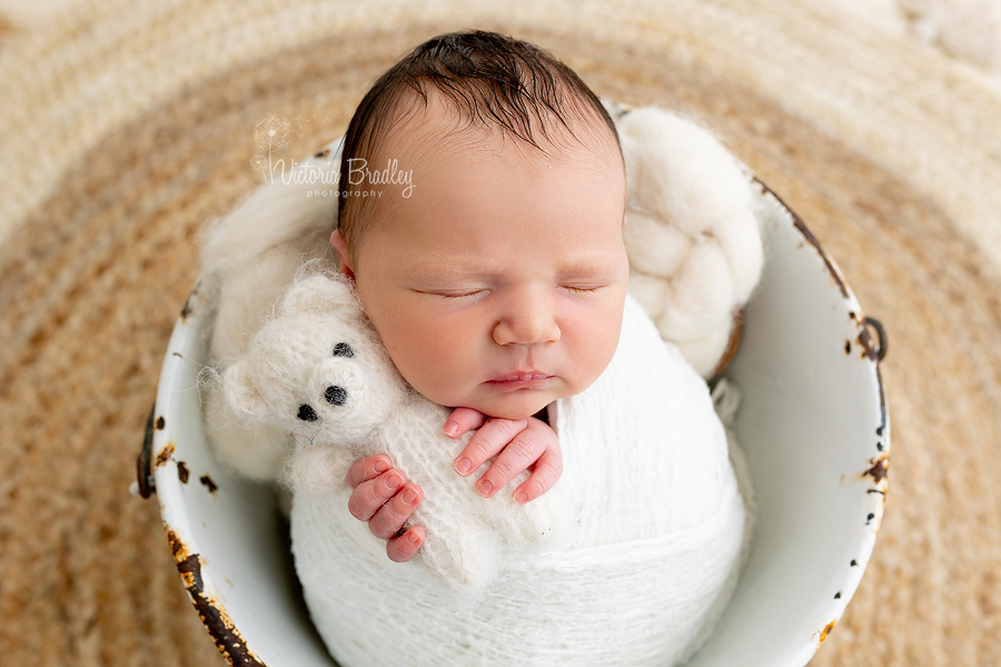 wrapped newborn holding little teddy